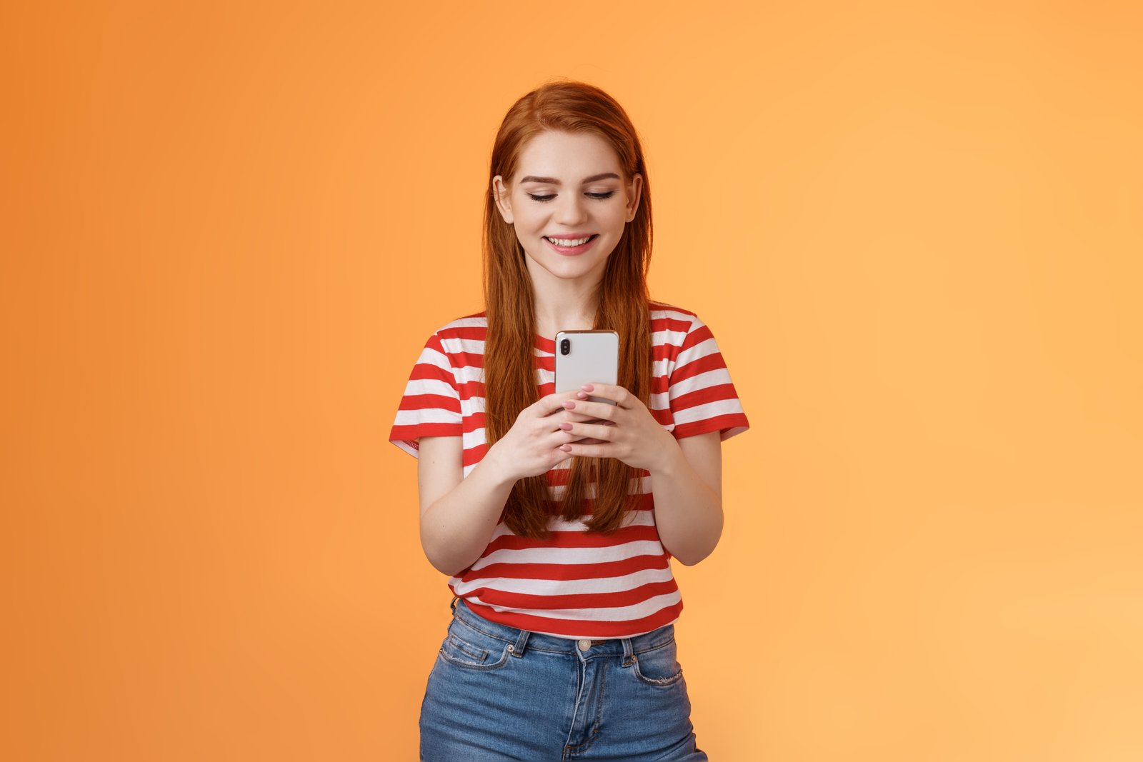 friendly outgoing modern ginger girl communicating friends chatting send funny memes hold smartphone